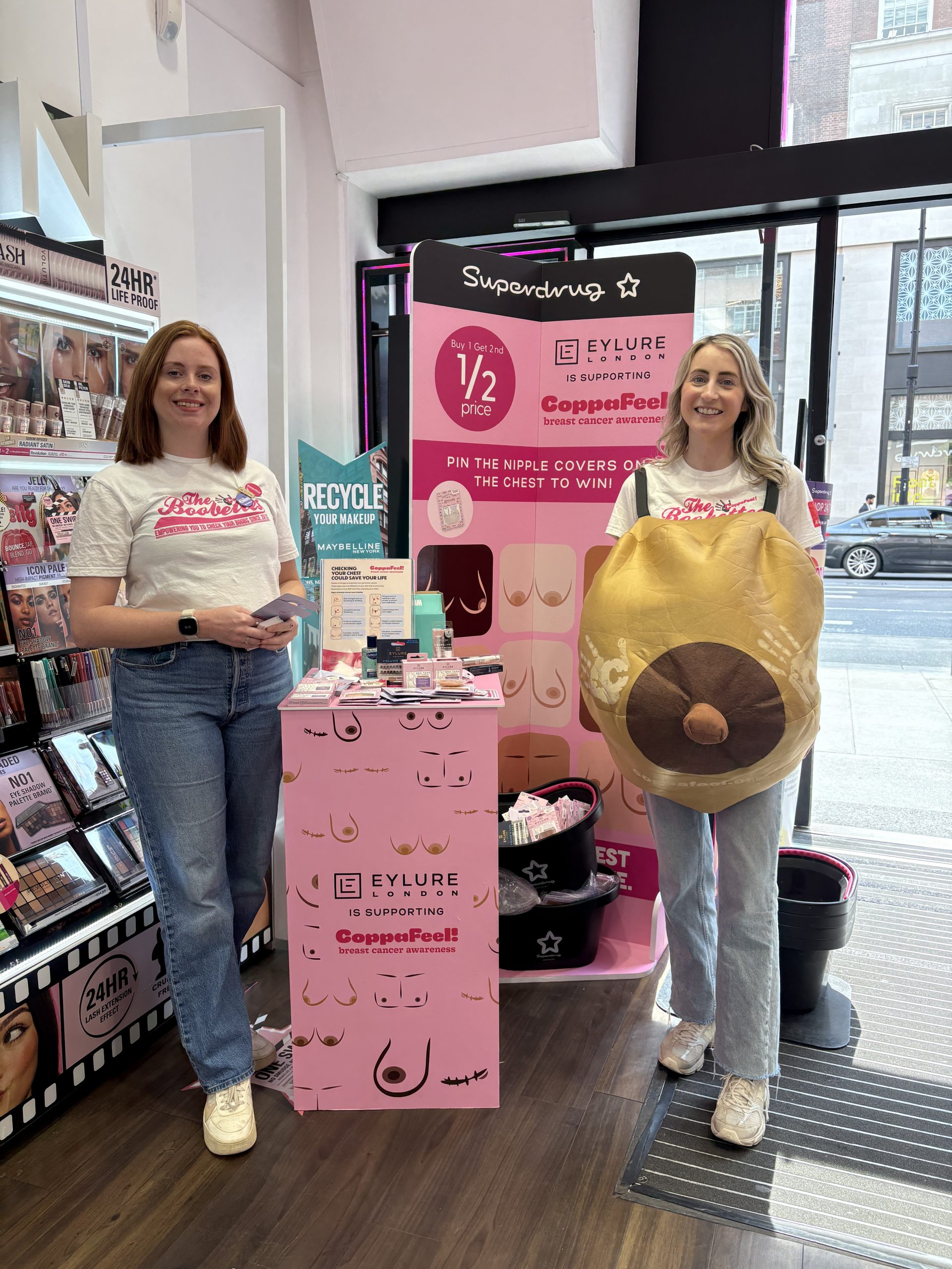 Two of the CoppaFeel! boobettes stood in Superdrug wearing a CoppaFeel! boob suit