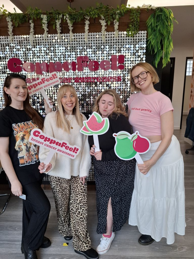 A group of our Boobettes stood holding CoppaFeel! fruit themed props
