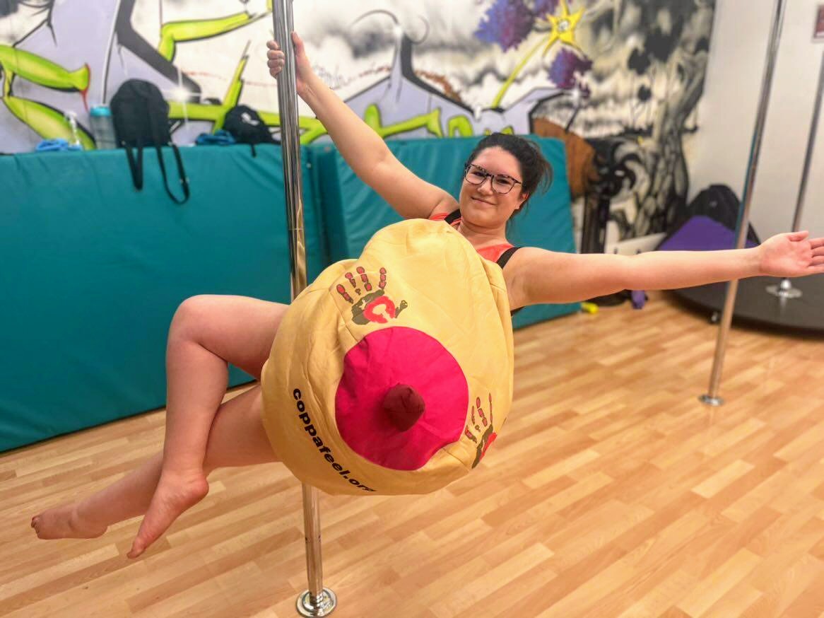 A volunteer on a pole wearing a CoppaFeel! boob suit